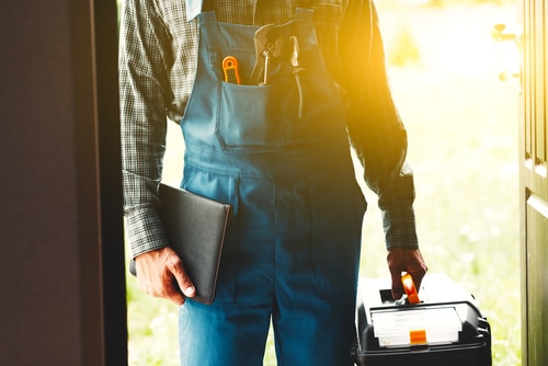 llustration of a plumber holding a wrench and a laptop, representing the importance of online reviews and ratings when choosing a plumber in Los Angeles.