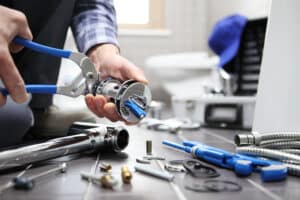 Plumber inspecting pipe with wrench - tips for finding a reliable plumber in Los Angeles